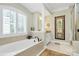 This luxurious bathroom features a large soaking tub with a large window, a walk-in shower, and decorative art at 13824 Glen Abbey Dr, Charlotte, NC 28278