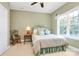 Cozy bedroom features a large window, decorative bed frame, and a rocking chair in neutral colors at 13824 Glen Abbey Dr, Charlotte, NC 28278