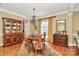 Elegant dining room featuring a round table, hardwood floors, and a classic china cabinet at 13824 Glen Abbey Dr, Charlotte, NC 28278