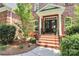 Inviting front entrance with brick steps, black double doors, and manicured landscaping at 13824 Glen Abbey Dr, Charlotte, NC 28278