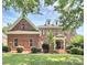 Stunning two-story brick home featuring manicured landscaping and a charming front entrance at 13824 Glen Abbey Dr, Charlotte, NC 28278