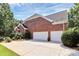 Spacious three-car garage with ample driveway space, set against a lush green backdrop at 13824 Glen Abbey Dr, Charlotte, NC 28278