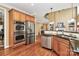Gourmet kitchen features stainless steel appliances, double ovens, granite countertops, and hardwood flooring at 13824 Glen Abbey Dr, Charlotte, NC 28278