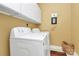 Laundry room with washer, dryer, storage cabinets and cheery decor at 13824 Glen Abbey Dr, Charlotte, NC 28278