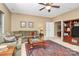 This comfortable living room features a ceiling fan, an area rug, and a comfortable green sofa at 13824 Glen Abbey Dr, Charlotte, NC 28278