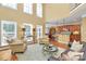Open-concept living room featuring hardwood floors, high ceilings, large windows, and seamless access to the kitchen at 13824 Glen Abbey Dr, Charlotte, NC 28278