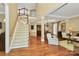 This well-lit living room features an open floor plan, hardwood floors, and a carpeted staircase to the second floor at 13824 Glen Abbey Dr, Charlotte, NC 28278
