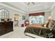 This spacious bedroom features tray ceilings, large windows, and a lovely seating area with access to the ensuite bathroom at 13824 Glen Abbey Dr, Charlotte, NC 28278