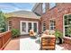 Outdoor patio with brick exterior, patio furniture and a bright rug at 13824 Glen Abbey Dr, Charlotte, NC 28278