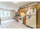This kitchen features white tile floors, oak cabinets, and natural light from a nearby window at 1713 Poe Cir, Hickory, NC 28601