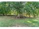 Lush backyard boasts mature trees, green grass, and a partial house view at 1735 Robinwood Rd, Gastonia, NC 28054