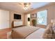 Well-lit bedroom features a ceiling fan, TV, window, and light-colored walls at 1735 Robinwood Rd, Gastonia, NC 28054