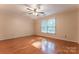 A room with hardwood flooring, ceiling fan, neutral colored walls, and a large window with natural light at 1735 Robinwood Rd, Gastonia, NC 28054
