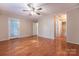 Large primary bedroom with wood-look floors, ceiling fan, neutral walls, back patio access, and access to a bathroom at 1735 Robinwood Rd, Gastonia, NC 28054