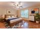 Staged primary bedroom with wood-look floors, ceiling fan, neutral walls, and natural light from the window at 1735 Robinwood Rd, Gastonia, NC 28054
