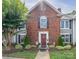 Beautiful brick townhome showcasing a red door, elegant shutters, and manicured landscaping at 1735 Robinwood Rd, Gastonia, NC 28054