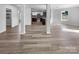 Open floor plan showcasing hardwood floors flowing into the kitchen with white cabinetry and stainless steel appliances at 1958 Leesburg Dr, Clover, SC 29710
