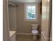 Cozy bathroom with window, toilet, and shower-tub combination at 201 Park Ave, Mount Holly, NC 28120