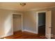 Neutral bedroom features hardwood floors, closet, base molding and access to another room at 201 Park Ave, Mount Holly, NC 28120