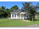 Quaint single-story home with a charming front porch and mature trees in a well-kept yard at 201 Park Ave, Mount Holly, NC 28120