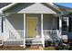 Inviting front porch features a bright yellow door and a cozy porch swing at 201 Park Ave, Mount Holly, NC 28120