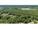 Panoramic aerial shot showcasing a lush, wooded area with the serene waters of a distant lake at 2074 Brandt Rd, York, SC 29745
