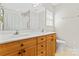 Bright bathroom featuring a double vanity, wood cabinets, and a large mirror at 210 Oak Village Pkwy, Mooresville, NC 28117