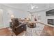 Cozy living room featuring a ceiling fan, fireplace, access to the outdoors, and comfortable leather furniture at 210 Oak Village Pkwy, Mooresville, NC 28117