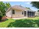 Back exterior view, featuring an enclosed sunroom and lush green lawn at 210 Oak Village Pkwy, Mooresville, NC 28117