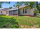 Back exterior featuring sunroom with screened windows, on a green lawn at 210 Oak Village Pkwy, Mooresville, NC 28117