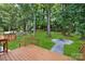 Serene backyard with wooden deck, stone pathway, a fire pit, and lush green lawn at 2120 Shadyview Dr, Charlotte, NC 28210