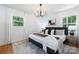 Bright bedroom features a modern chandelier, hardwood floors, and neutral decor at 2120 Shadyview Dr, Charlotte, NC 28210