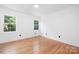 Bright bedroom with hardwood floors, two windows, and fresh white walls at 2120 Shadyview Dr, Charlotte, NC 28210