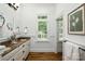 Well-lit bathroom featuring double sinks, stone countertops, and wood-look flooring at 3408 Sandalwood Ln, Waxhaw, NC 28173