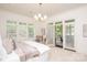 Bright bedroom with a sitting area, a large window, a door to the backyard, and neutral colors at 3408 Sandalwood Ln, Waxhaw, NC 28173