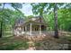 Charming home with a stone chimney and a covered porch surrounded by trees at 3408 Sandalwood Ln, Waxhaw, NC 28173