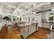 Open kitchen and dining area with a large island, coffered ceiling, and stainless steel appliances at 3408 Sandalwood Ln, Waxhaw, NC 28173
