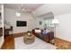 Living room features a ceiling fan, TV and a brown leather couch at 3408 Sandalwood Ln, Waxhaw, NC 28173