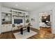 Well-lit office with built-in shelves and a view into the living room at 3408 Sandalwood Ln, Waxhaw, NC 28173