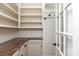 Walk-in pantry with open shelving, granite countertops, cabinets, and a charming door at 3408 Sandalwood Ln, Waxhaw, NC 28173