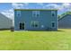 Spacious backyard with lush green lawn and a two-story home with a blue facade at 3654 Azalea Ridge Dr, Mount Holly, NC 28102