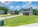 View of multiple two-story homes featuring stone accents, attached two-car garages, and large lawns at 3654 Azalea Ridge Dr, Mount Holly, NC 28102