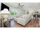 Spacious living room featuring hardwood floors, comfortable furniture, natural lighting, and kitchen view at 3654 Azalea Ridge Dr, Mount Holly, NC 28102