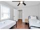 Bright bedroom featuring two twin beds, hardwood floors, and a modern ceiling fan at 3909 Woodbriar Trl, Charlotte, NC 28205