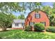 Charming two-story red brick home with a detached garage and lush landscaping at 3909 Woodbriar Trl, Charlotte, NC 28205