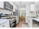 Modern kitchen features white cabinetry, stainless appliances, and a seamless flow to the dining area at 3909 Woodbriar Trl, Charlotte, NC 28205
