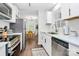 Updated kitchen with white cabinets, stainless steel appliances, and view into dining area at 3909 Woodbriar Trl, Charlotte, NC 28205