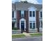 Charming brick townhome featuring a white picket fence and a welcoming dark-blue front door at 4103 Christine Ln # E, Waxhaw, NC 28173