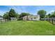 Wide shot of the backyard with lush green grass, wooden fence, and back deck at 4507 Mackinac St, Charlotte, NC 28269