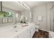 This bathroom features dual sinks, a large mirror with Hollywood lighting, and elegant decor at 4507 Mackinac St, Charlotte, NC 28269